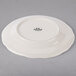 A Tuxton ivory china plate with a scalloped edge.