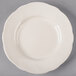 A Tuxton Shell china plate with a scalloped edge on a gray surface.
