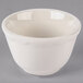 A white Tuxton china bowl with a scalloped edge.