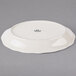 A white Tuxton oval china platter with a scalloped edge.