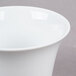 A close-up of a CAC bright white porcelain cup with a white rim.