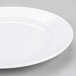 A close-up of an Elite Global Solutions white melamine plate with a white rim.