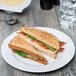 A sandwich on a white Elite Global Solutions melamine plate.