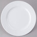 A white Elite Global Solutions round melamine platter with a white rim on a gray surface.