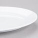 An Elite Global Solutions white oval melamine plate with a rim.