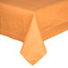 A table with a Creative Converting Pumpkin Spice Orange tablecloth on it.