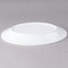 An Elite Global Solutions white oval melamine plate on a gray surface.