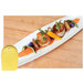 A white plate with food on it and a yellow Mercer Culinary saw tooth edge plating tool.