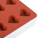 A red and white Martellato silicone heart mold with 24 compartments.
