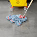 A Rubbermaid blue looped end wet mop next to a yellow bucket.