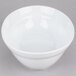 A white oval serving bowl on a gray surface.