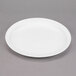 A white Libbey porcelain plate with a rim on a gray surface.