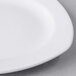 A close up of a white Libbey square porcelain plate with a small rim.