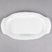 A white Libbey porcelain platter with a curved edge on a gray surface.