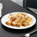 A Libbey white porcelain plate with French toast and syrup on it.