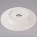 A white Tuxton Hampshire China bread and butter plate with black embossed text.