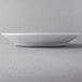 A white Libbey Royal Rideau porcelain entree and pasta bowl on a white plate.