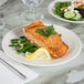 A Tuxton Hampshire china plate with a plate of salmon, green beans, and a lemon wedge.
