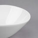 A close-up of a Libbey white porcelain bowl with a curved edge.