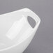 A close-up of a white Libbey porcelain bowl with a handle.