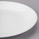 A close-up of a Libbey white porcelain coupe plate with a white rim.