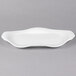 A white Libbey porcelain platter with a curved edge.