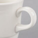 A close-up of a white Libbey tall porcelain tea cup with a handle.