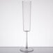 A Fineline clear plastic champagne flute with a long stem on a table.