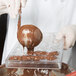 A person pouring chocolate into a Matfer Bourgeat chocolate mold.