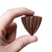 A hand holding a chocolate triangle made with a Matfer Bourgeat striped triangle chocolate mold.