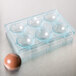 A clear plastic Matfer Bourgeat chocolate mold tray with round brown half spheres.