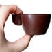 A hand holding a brown Martellato espresso cup made with a Martellato chocolate mold.