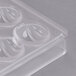 A clear plastic Matfer Bourgeat chocolate mold with half circles.