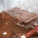Chocolate being poured into a Chocolate World square candy mold.