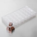 A clear plastic Chocolate World square mold with 32 compartments for chocolate pieces.