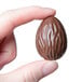 A hand holding a Matfer Bourgeat chocolate egg with a swirl pattern.