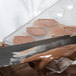 A knife spreading chocolate into a Chocolate World quenelle mold.