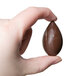 A hand holding a chocolate quenelle made with a Chocolate World polycarbonate mold.