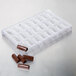 A white plastic polycarbonate tray with 24 bullion-shaped chocolates.