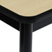 A close up of a Correll Fusion Maple library table with a black base.