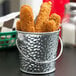A Tablecraft galvanized steel pail filled with fried chicken strips.