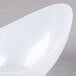 A close up of a white Fineline Tiny Tureens bowl with a curved edge.