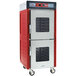 A red and silver Metro hot holding cabinet with clear Dutch doors.