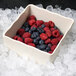 A GET Create-a-Bar deli crock filled with raspberries and blueberries on ice.