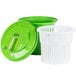 A green and white plastic salad spinner with a lid.