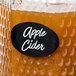 A jar of apple cider with a black oval vinyl chalkboard label with white text on it.