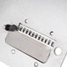 A metal Nemco Noodler front plate assembly with a rectangular hole and holes around it.