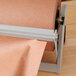 A Bulman 24" steel paper dispenser/cutter on a table holding a roll of brown paper.