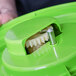 A green plastic container with a white gear inside.