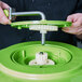 A hand holding a green and white gear for a Large Gear Salad Spinner.
